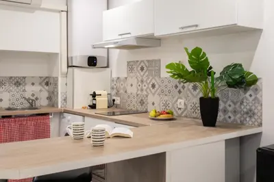a kitchen with white cabinets and a wooden counter top at Cannes Hyper Centre climatisé in Cannes