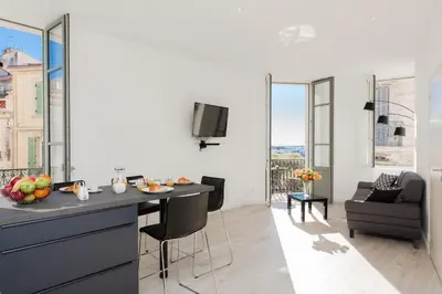 a kitchen and living room with a table and chairs at Anzur YourHostHelper in Cannes