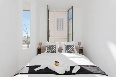 a bedroom with a white bed with two pillows at Anzur YourHostHelper in Cannes