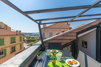 a balcony with a table with food on it at Anzur YourHostHelper in Cannes
