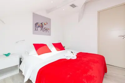 a bedroom with a red and white bed with red pillows at Anzur YourHostHelper in Cannes