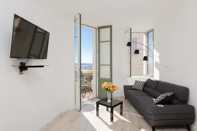 a living room with a couch and a flat screen tv at Anzur YourHostHelper in Cannes