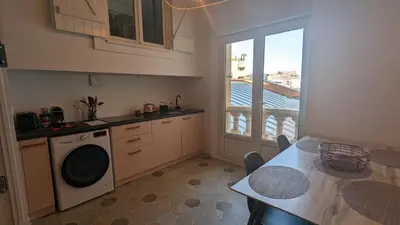 a kitchen with a table and a balcony with a view at Appartement T3 , 650m du Palais des Festivals in Cannes