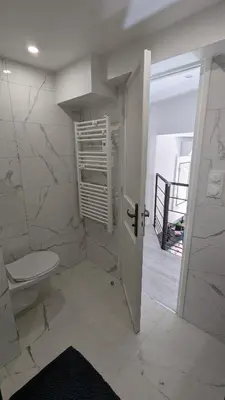 a white bathroom with a toilet and a staircase at Appartement T3 , 650m du Palais des Festivals in Cannes