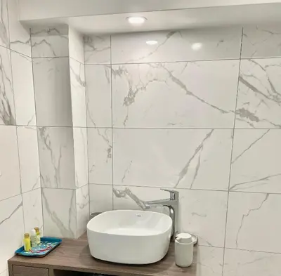 a bathroom with a sink and a marble wall at Appartement T3 , 650m du Palais des Festivals in Cannes