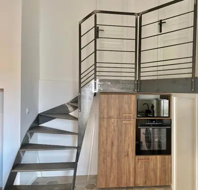 a staircase leading up to a kitchen with a microwave at Appartement T3 , 650m du Palais des Festivals in Cannes