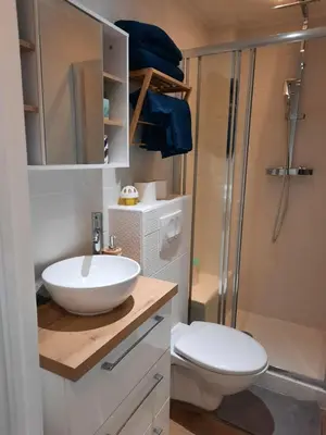 a dining room with a glass table and two white chairs at T2 neuf, balcon, centre Cannes, 15 min du Palais in Cannes