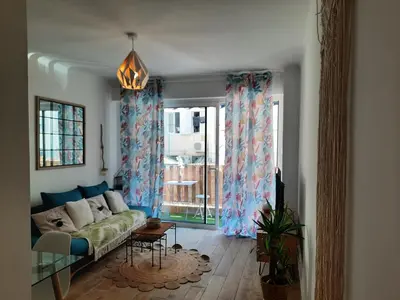 a living room with a couch and a window at T2 neuf, balcon, centre Cannes, 15 min du Palais in Cannes
