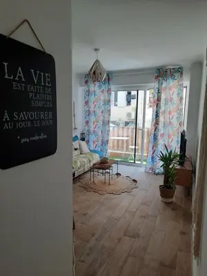 a living room with a large window and a couch at T2 neuf, balcon, centre Cannes, 15 min du Palais in Cannes