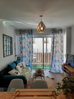 a living room with a blue couch and a large window at T2 neuf, balcon, centre Cannes, 15 min du Palais in Cannes