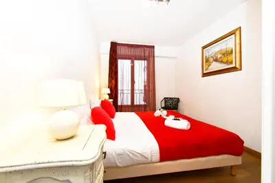 a bedroom with a red and white bed and a window at The Old Port chez Antonella in Cannes
