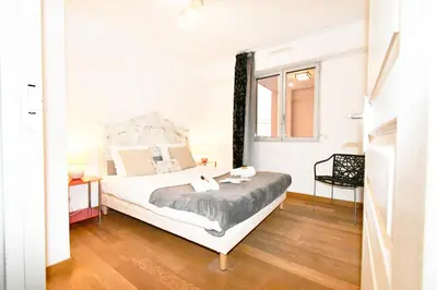 a bedroom with a white bed and a window at The Old Port chez Antonella in Cannes