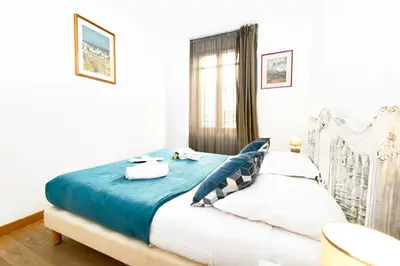 a bedroom with a bed with blue and white sheets at The Old Port chez Antonella in Cannes