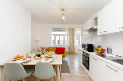 a kitchen and living room with a table and chairs at Lumière YourHostHelper in Cannes