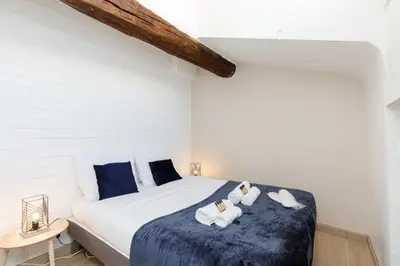 a bedroom with a bed with towels on it at Lumière YourHostHelper in Cannes