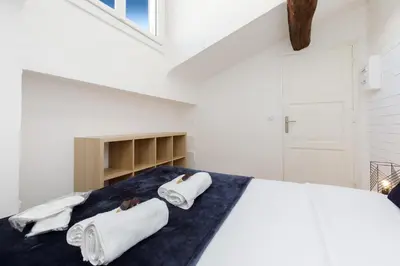 a bedroom with a bed with towels on it at Lumière YourHostHelper in Cannes
