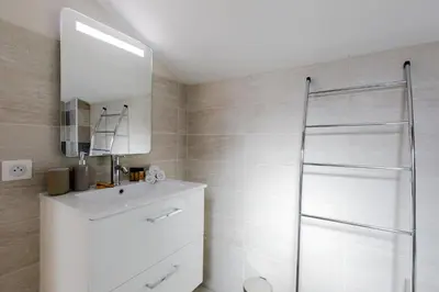 a bathroom with a white sink and a mirror at Lumière YourHostHelper in Cannes