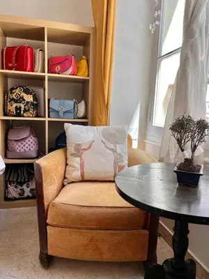 a living room with a chair and a table and a shelf at Centre heart of CAnnes in Cannes