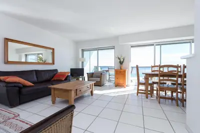 a living room with a couch and a table at Bright two bedroomed apartment on the beach in Cannes with huge terrace with fabulous sea views - 2001 in Cannes