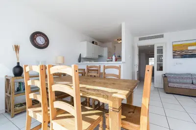a kitchen and dining room with a wooden table and chairs at Bright two bedroomed apartment on the beach in Cannes with huge terrace with fabulous sea views - 2001 in Cannes