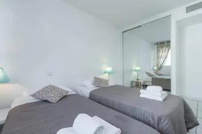 two beds in a room with a mirror at Bright two bedroomed apartment on the beach in Cannes with huge terrace with fabulous sea views - 2001 in Cannes