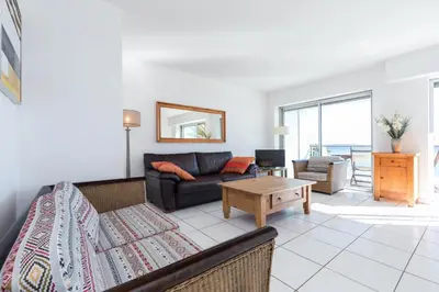 a living room with a couch and a table at Bright two bedroomed apartment on the beach in Cannes with huge terrace with fabulous sea views - 2001 in Cannes