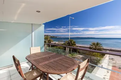 a table and chairs on a balcony with a view of the ocean at Bright two bedroomed apartment on the beach in Cannes with huge terrace with fabulous sea views - 2001 in Cannes