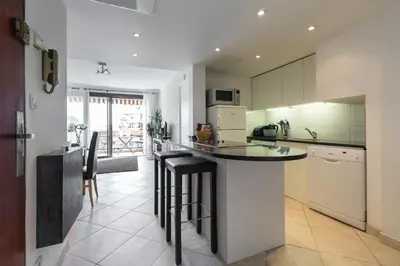 a kitchen with a counter and some chairs in it at Modern 3 bedroom 3 bathroom apartment for rent near Cannes Old Town walking distance to Palais - 2000 in Cannes