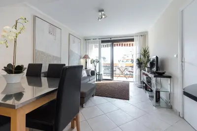 a dining room and living room with a table and chairs at Modern 3 bedroom 3 bathroom apartment for rent near Cannes Old Town walking distance to Palais - 2000 in Cannes