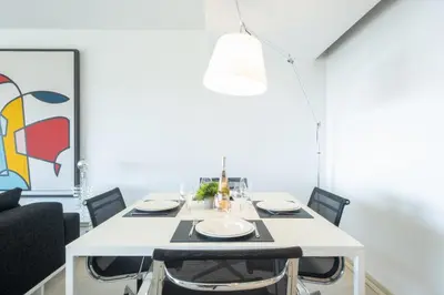 a dining room with a white table and chairs at Elegant 3-Room Apartment with Terrace Pool & Island Views in Cannes