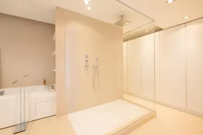 a white bathroom with a shower and a sink at Elegant 3-Room Apartment with Terrace Pool & Island Views in Cannes
