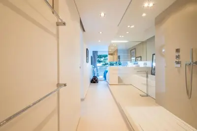 a hallway of a kitchen with white walls and white floors at Elegant 3-Room Apartment with Terrace Pool & Island Views in Cannes