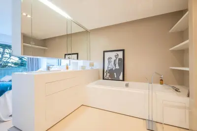 a white bathroom with a sink and a mirror at Elegant 3-Room Apartment with Terrace Pool & Island Views in Cannes