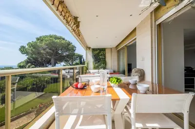 a dining room with a table and chairs on a balcony at Elegant 3-Room Apartment with Terrace Pool & Island Views in Cannes