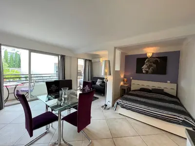 a bedroom with a bed and a table and a dining room at Rouaze 2, by Welcome to Cannes in Cannes