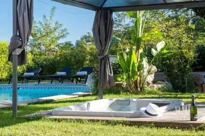 a bath tub in the grass next to a pool at VILLA 330m2 heated pool and Jacuzzi in Vallauris
