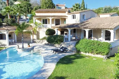 a house with a swimming pool in front of a yard at VILLA 330m2 heated pool and Jacuzzi in Vallauris