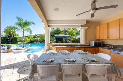 a kitchen with a table and chairs and a pool at VILLA 330m2 heated pool and Jacuzzi in Vallauris