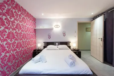 a bedroom with a large white bed with a red wall at VILLA 330m2 heated pool and Jacuzzi in Vallauris