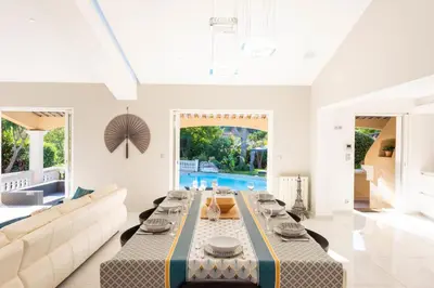 a living room with a table and a couch at VILLA 330m2 heated pool and Jacuzzi in Vallauris