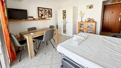 a bedroom with a bed and a table and chairs at Cannes center - very practical - all comfort in Cannes