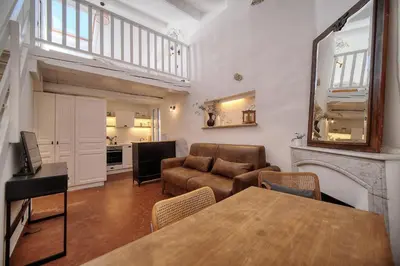 a living room with a table and a couch at IMMOGROOM - Cosy - Renovated duplex - Close to the beach in Cannes