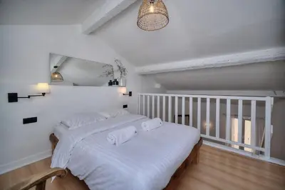 two beds in a room with white walls at IMMOGROOM - Cosy - Renovated duplex - Close to the beach in Cannes