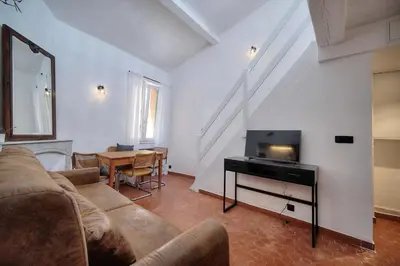 a living room with a couch and a television at IMMOGROOM - Cosy - Renovated duplex - Close to the beach in Cannes