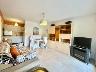 a living room with a couch and a kitchen with a table at Cannes center 2, by Welcome to Cannes in Cannes