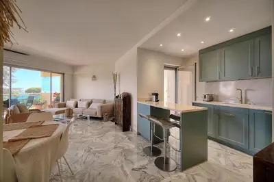 a kitchen with green cabinets and a living room at Somptueux 2 chambres vue MER, TERRASSE, PARKING A2B232 in Cannes