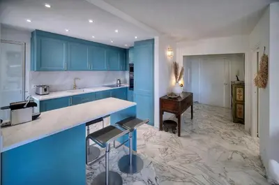 a large kitchen with blue cabinets and a desk at Somptueux 2 chambres vue MER, TERRASSE, PARKING A2B232 in Cannes
