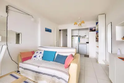 a living room with a couch and a kitchen at Résidence Cannes Villa Francia - maeva Home - Appartement climatisé avec vue mer 2 pièces 4 personnes - Prestige - super Home MAE-2644 in Cannes