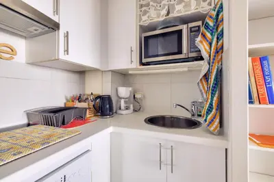 a small kitchen with a sink and a microwave at Résidence Cannes Villa Francia - maeva Home - Appartement climatisé avec vue mer 2 pièces 4 personnes - Prestige - super Home MAE-2644 in Cannes