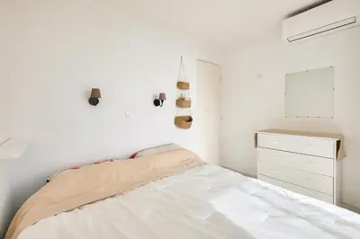 a white bedroom with a bed and a dresser at Résidence Cannes Villa Francia - maeva Home - Appartement climatisé avec vue mer 2 pièces 4 personnes - Prestige - super Home MAE-2644 in Cannes